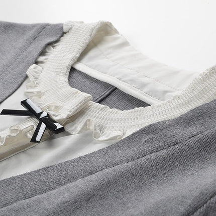 Gray A-line dress with white ruffle details and black bow accent
