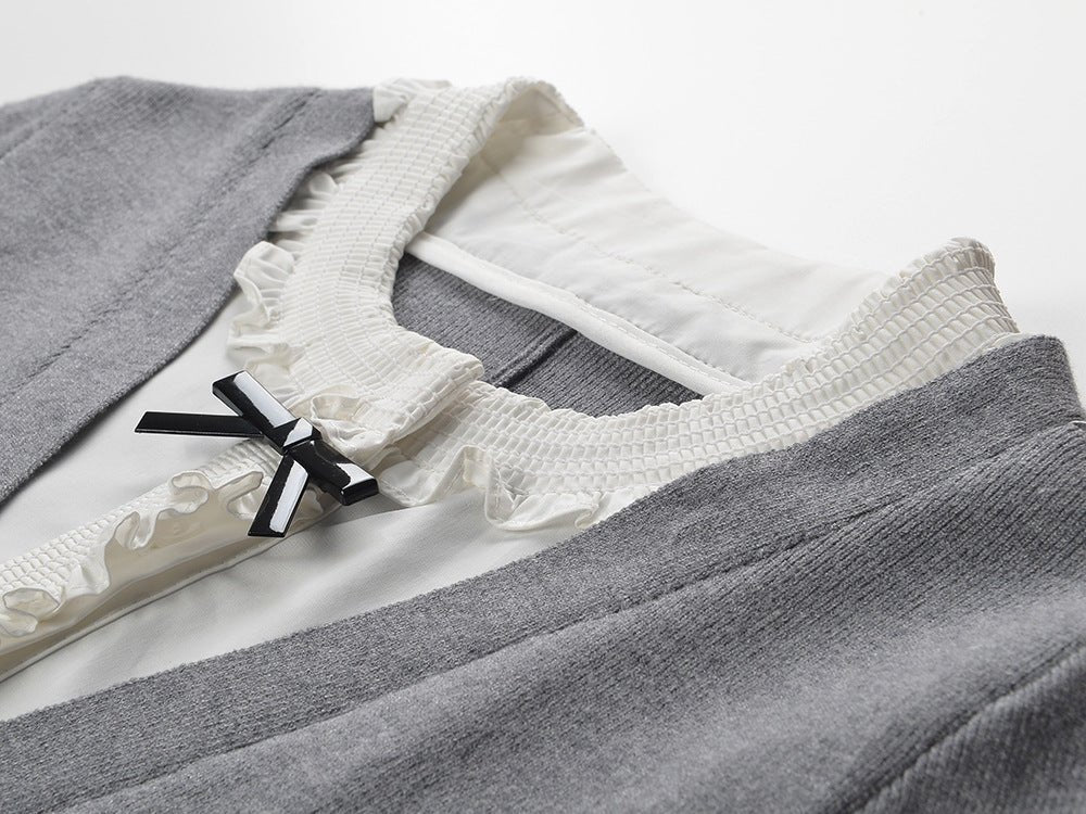 Gray A-line dress with white ruffle details and black bow accent