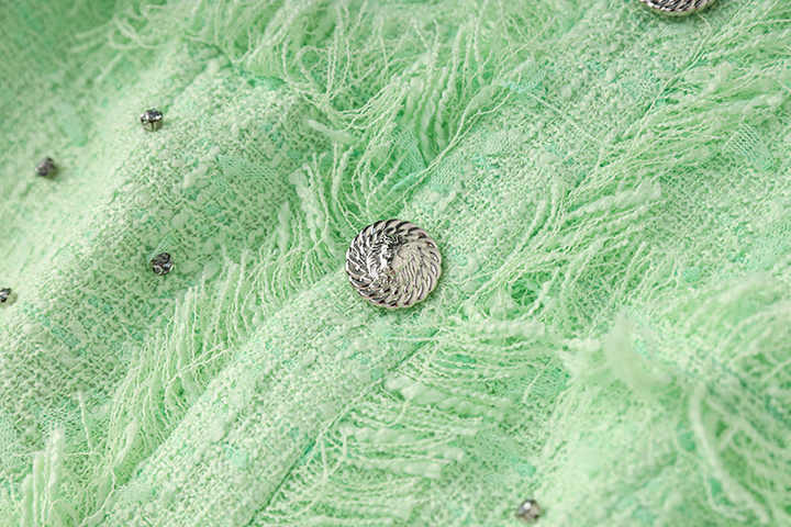 Green halter neck dress with rhinestone accents and frayed edges