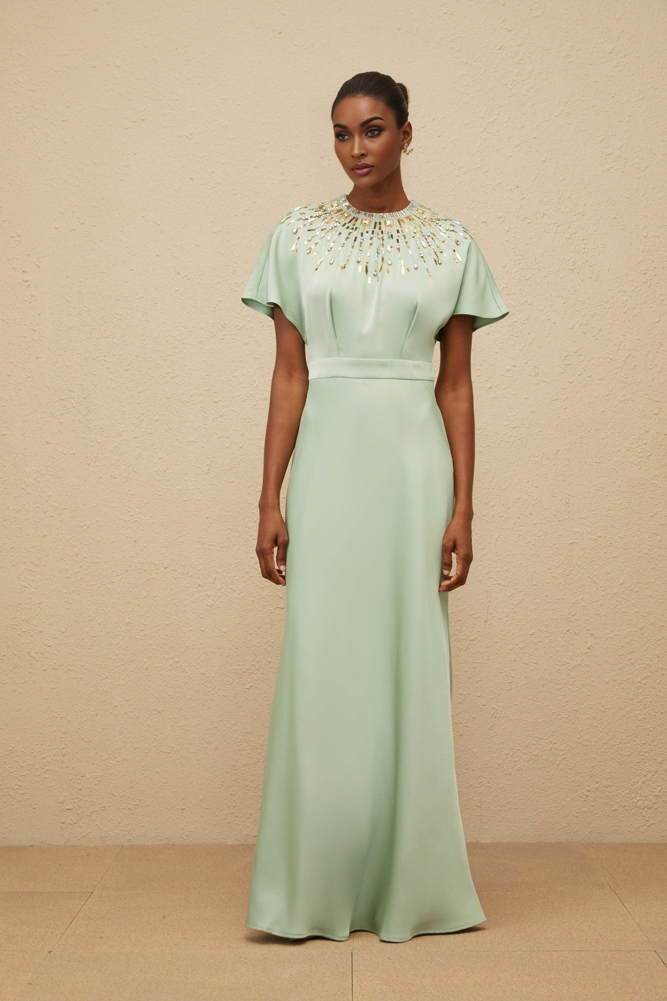 Green satin maxi dress with sequin, crystal, and bead embellishments, cinched waist, and open back