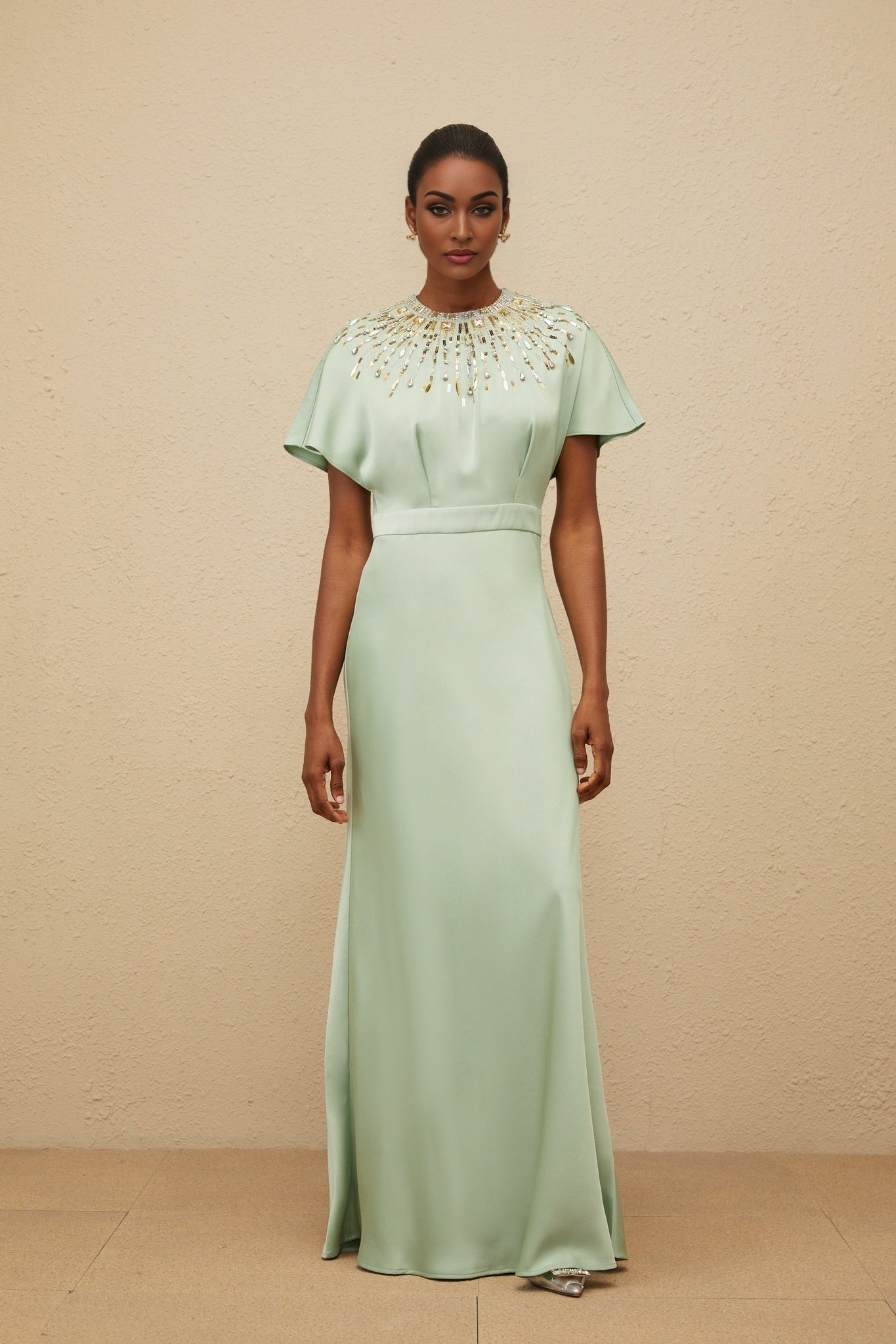 Green satin maxi dress with sequin, crystal, and bead embellishments, cinched waist, and open back