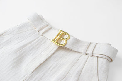 High-waisted tailored shorts in crisp white with signature buckle detail