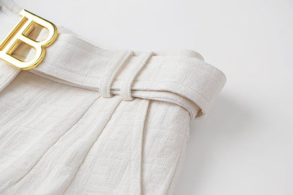 High-waisted white tailored shorts with buckle detail
