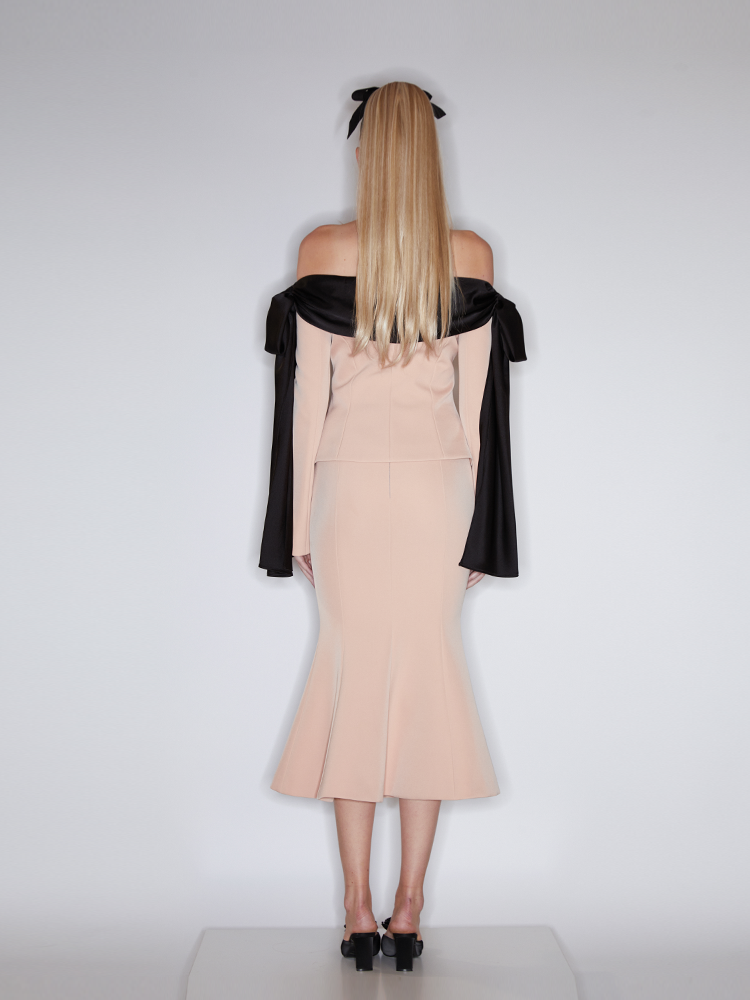 Beige high-waisted skirt with a fishtail silhouette, decorative gold-tone buttons, and structured details for an elegant and refined look.