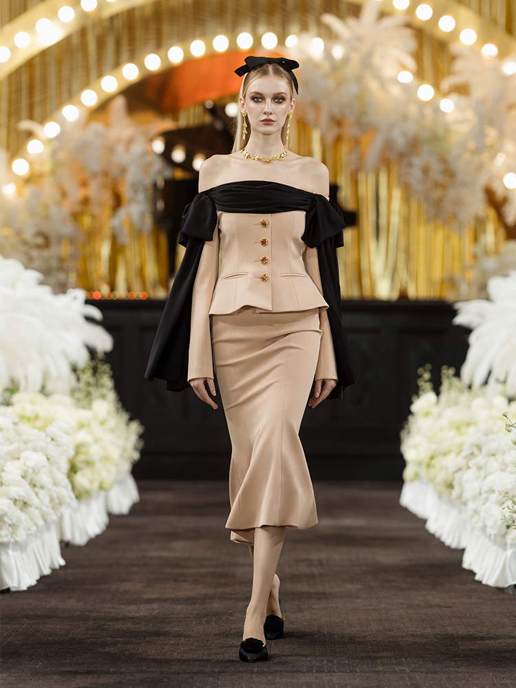 Beige high-waisted skirt with a fishtail silhouette, decorative gold-tone buttons, and structured details for an elegant and refined look.