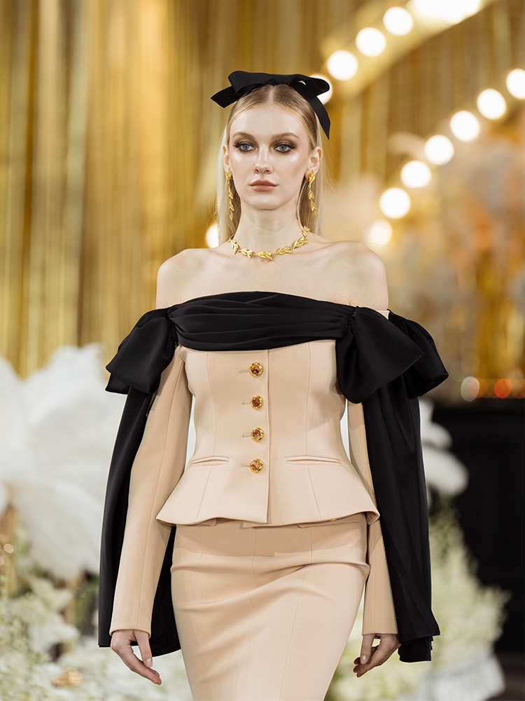 Beige high-waisted skirt with a fishtail silhouette, decorative gold-tone buttons, and structured details for an elegant and refined look.