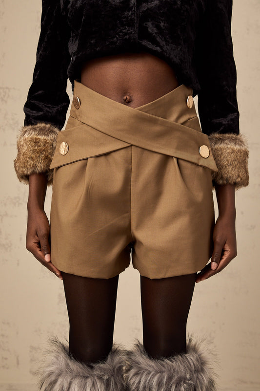 Khaki colored shorts with a crossover design at the waist featuring a loose fit and flowing fabric