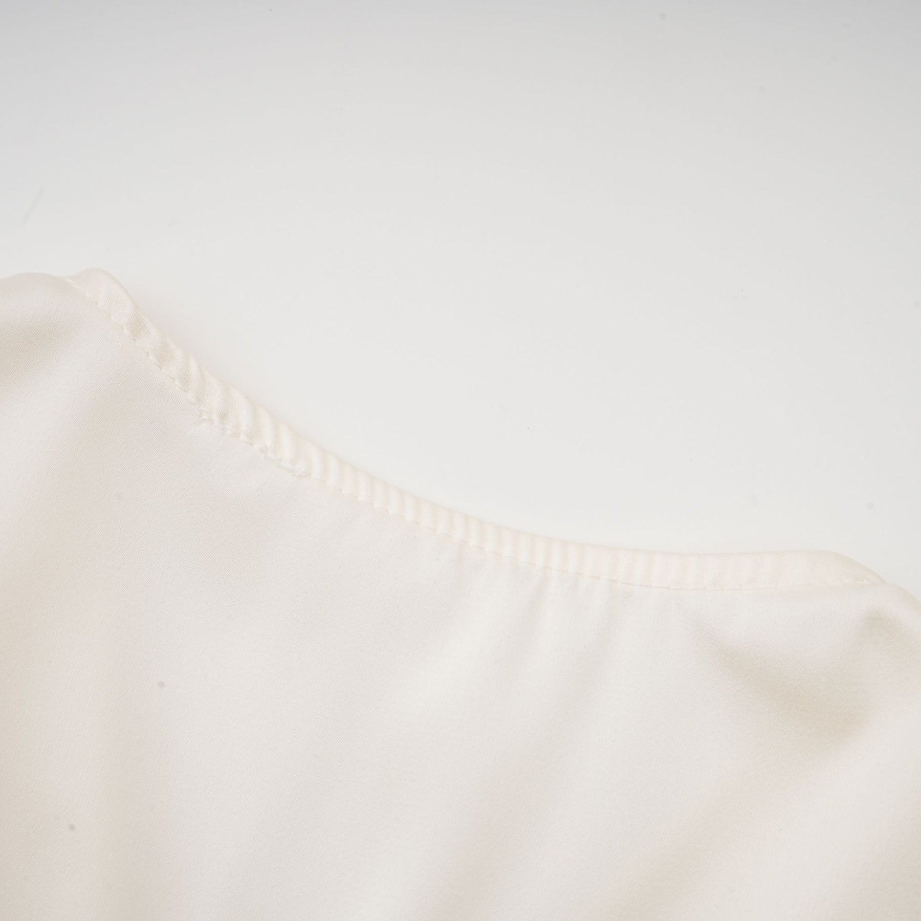 Kurzes weisses Oberteil mit gedrehtem Muster und dekorativen Kunstblumen vorne