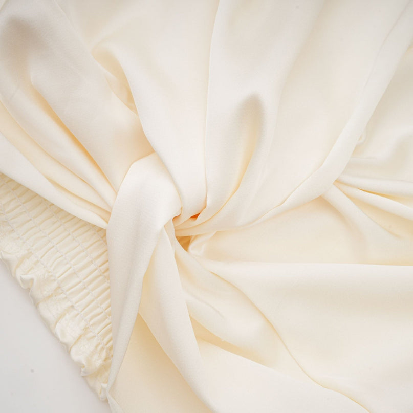 Kurzes weisses Oberteil mit gedrehtem Muster und dekorativen Kunstblumen