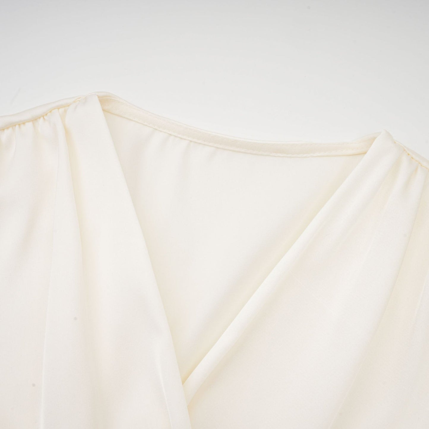 Kurzes weisses Oberteil mit gedrehtem Muster und dekorativen Kunstblumen