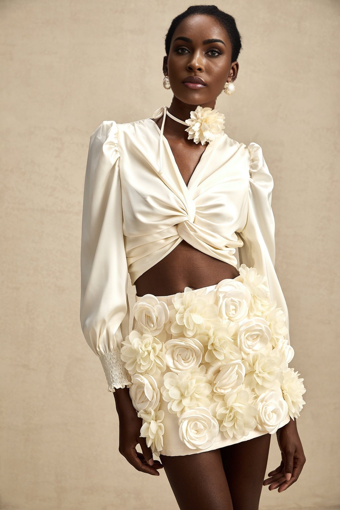 Kurzes weisses Oberteil mit gedrehtem Muster und dekorativen Kunstblumen