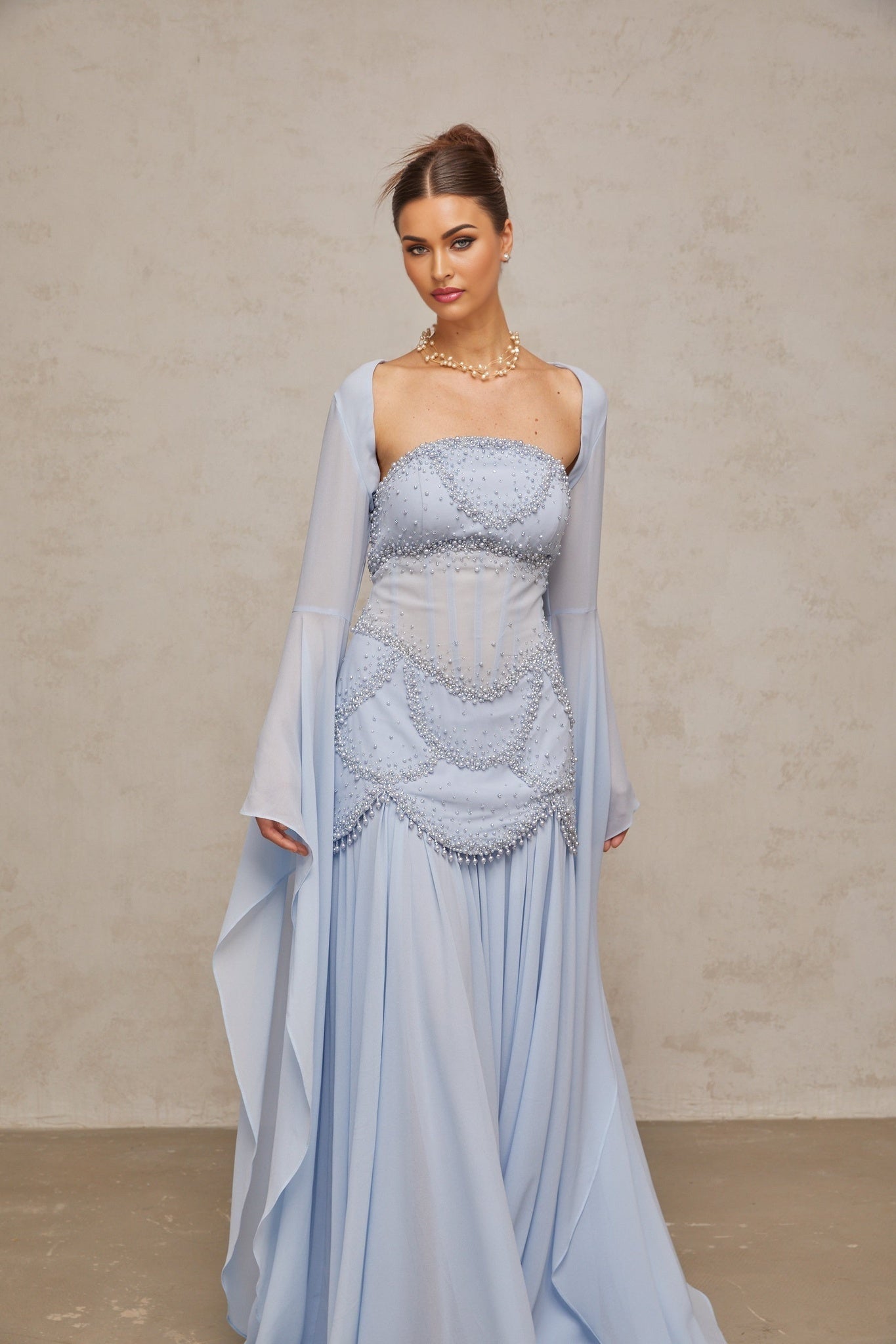 Light blue pleated maxi dress with faux pearl embellishments by Gaelle
