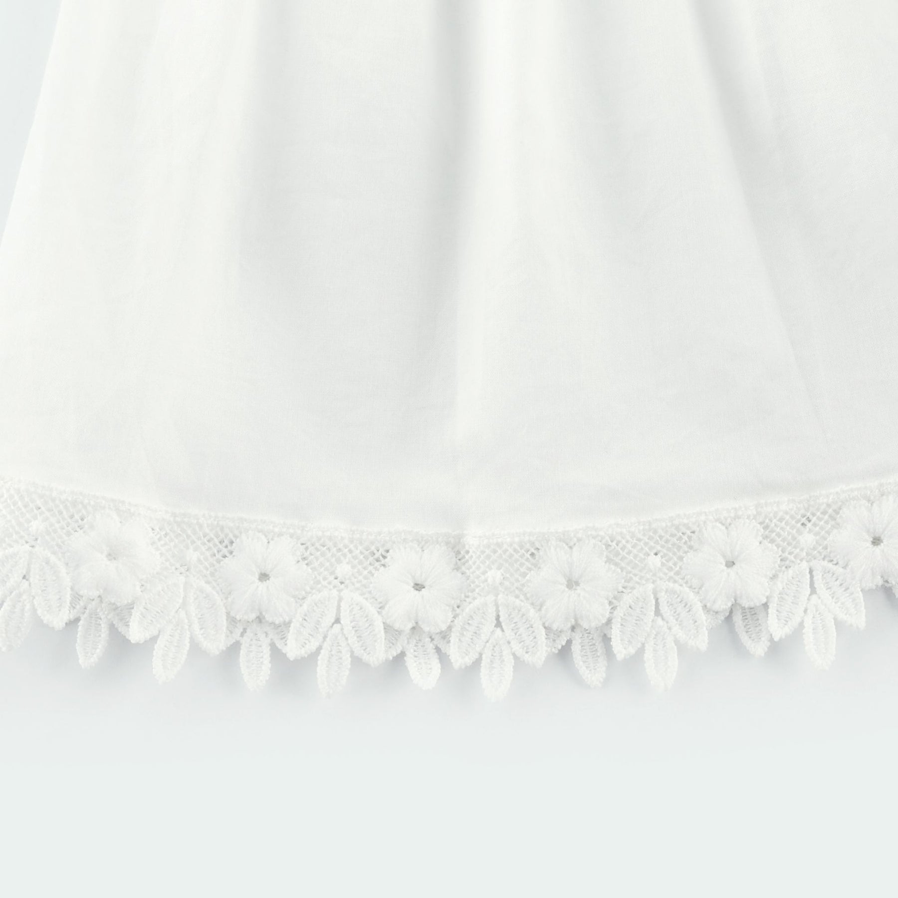 Light colored lace midi dress with floral embroidery details and feminine silhouette