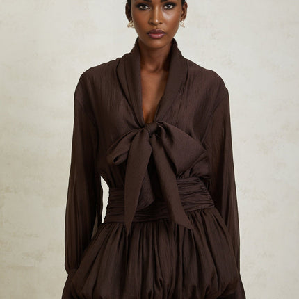 Lina Mini Dress in Brown long sleeves buttoned cuffs cinched waist ruched detailing ribbon tie-neck bubble hem skirt shirred effect side zip fastening 100% Terylene fiber