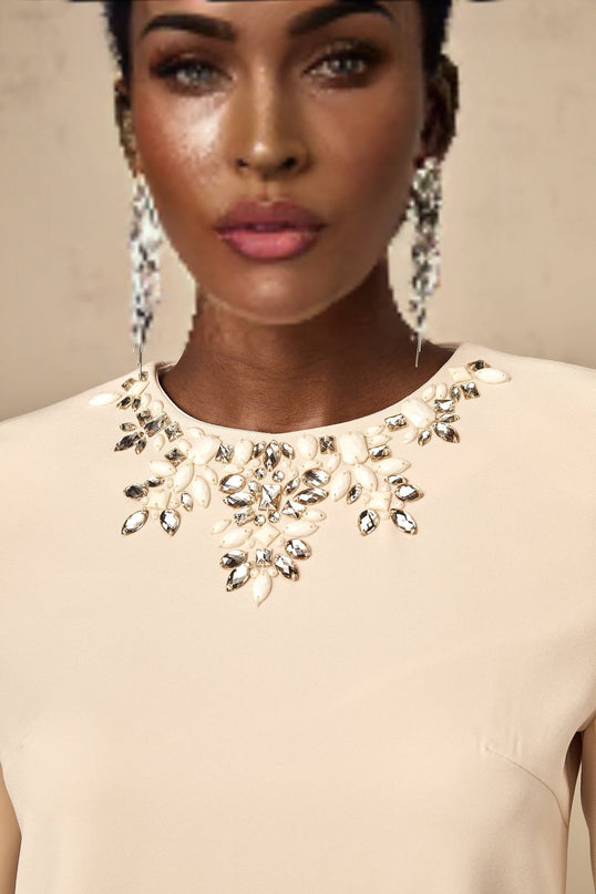 Long sleeved mini dress in neutral color with crystal embellishments