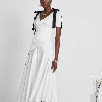 Mary Maxi Dress in White and Black with V-neck and Puff Sleeves Ribbon Design Pleat Detailing and Bowknot Embellishment 100% Polyester Fiber Flared Hem and Maxi Length Rear Zip Fastening