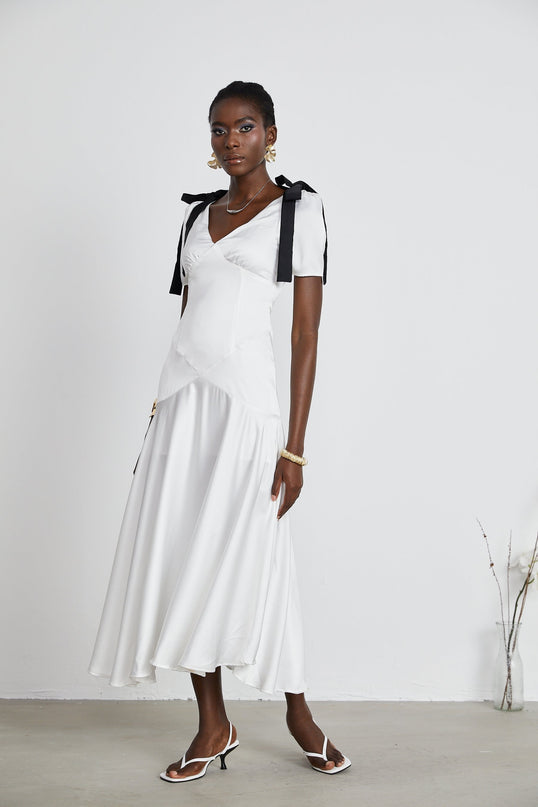 Mary Maxi Dress in White and Black with V-neck and Puff Sleeves Ribbon Design Pleat Detailing and Bowknot Embellishment 100% Polyester Fiber Flared Hem and Maxi Length Rear Zip Fastening