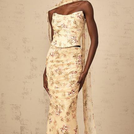 Matching yellow floral print outfit with fitted top and skirt on white background