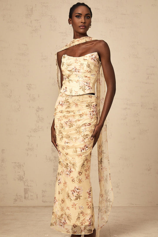 Matching yellow floral print outfit with fitted top and skirt on white background