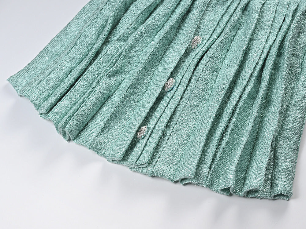 Mint green tweed jacket with floral embellishments paired with a pleated skirt, creating a chic and elegant look