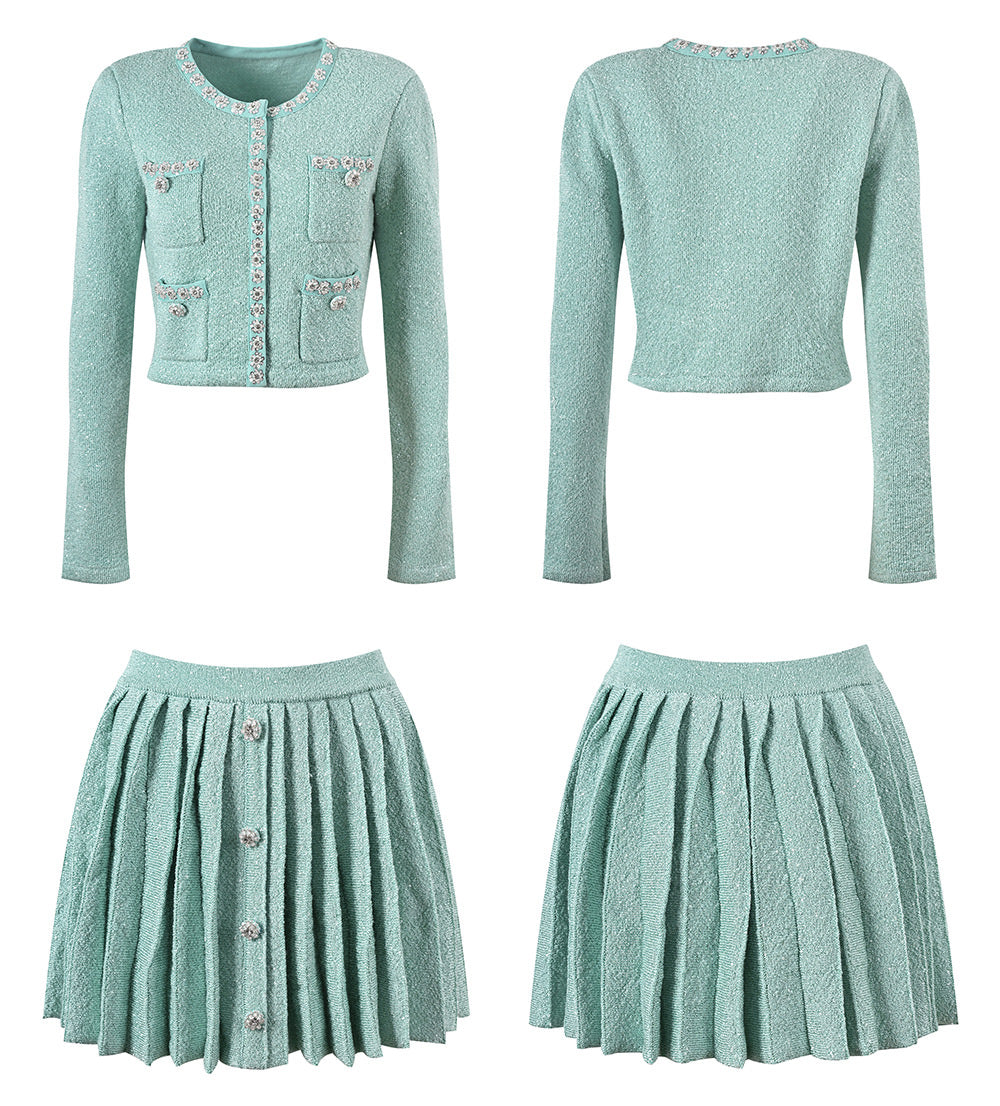 Mint green tweed jacket with floral embellishments paired with a pleated skirt, creating a chic and elegant look