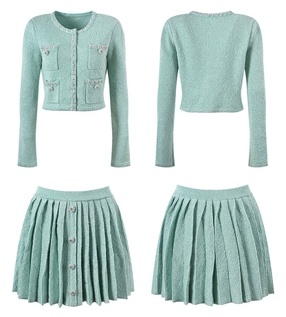 Mint green tweed jacket with floral embellishments paired with a pleated skirt, creating a chic and elegant look