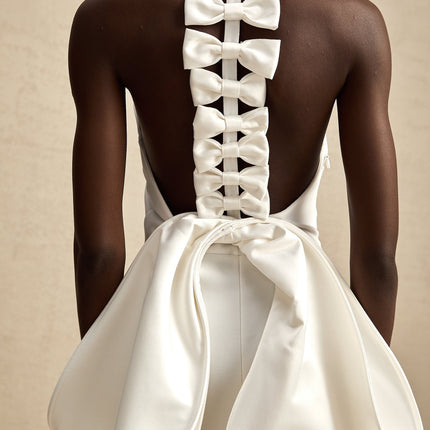 Natalia White Oversize-bow Maxi Dress with rear bowknot detail in polyester and spandex blend, round neck, rear slit, and size zip fastening for elegance and allure