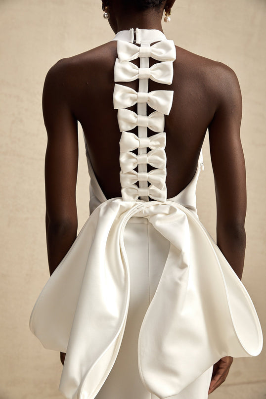 Natalia White Oversize-bow Maxi Dress with rear bowknot detail in polyester and spandex blend, round neck, rear slit, and size zip fastening for elegance and allure