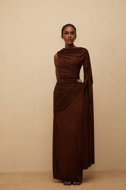 Nora Maxi Dress in Brown Sleeveless Bateau Neck Fitted Waistline Knitted Asymmetrical Ruched Detailing Ribbon Design Silver-tone Hardware Side Zip Fastening Graceful Maxi Length