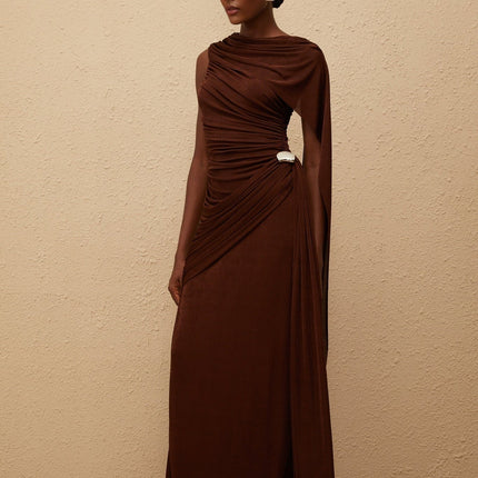 Nora Maxi Dress in Brown Sleeveless Bateau Neck Fitted Waistline Knitted Construction Asymmetrical Ruched Detailing Ribbon Design Embossed Silver-tone Hardware Side Zip Fastening Graceful Maxi Length