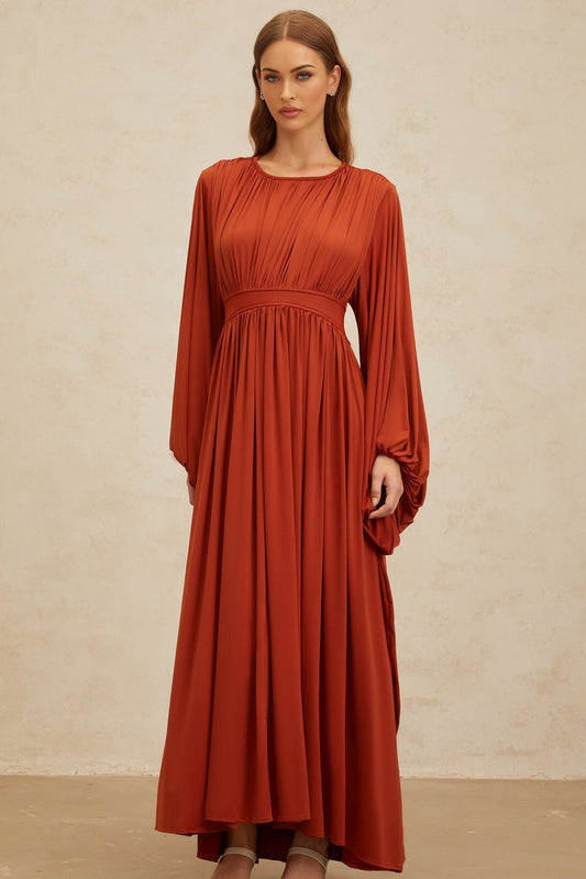 Orange maxi dress with long puff sleeves, cinched waist, and pleated detailing