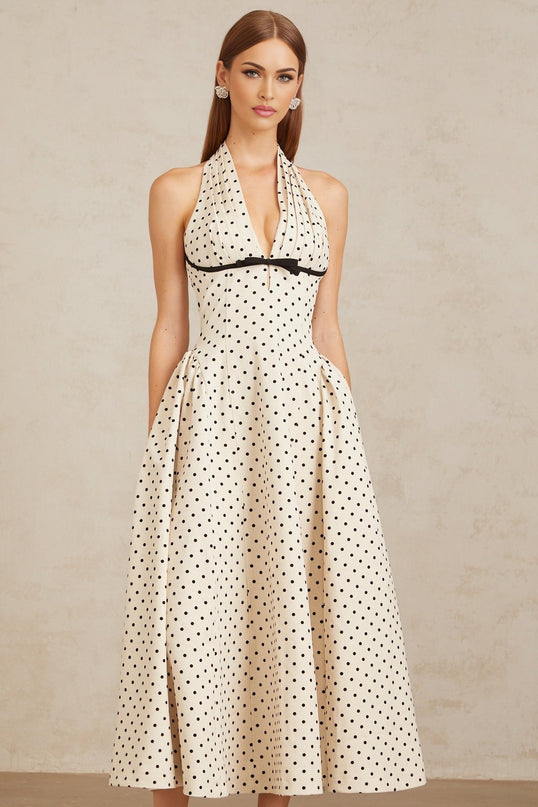 Ornella Midi Dress in White with Black Polka Dots sartorial masterpiece halterneck design open back bow embellishment playful polka-dot print puff skirt sophisticated silhouette attention to detail calf-length hemline rear button zip fastening special occasions classic charm contemporary style