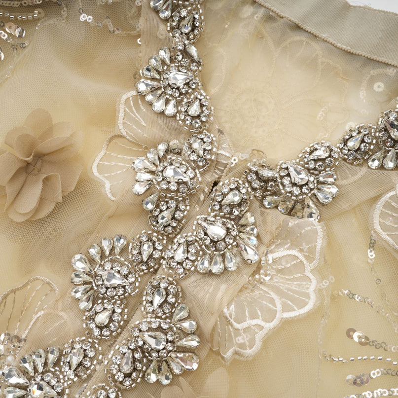 Paityn Floral Appliqué Jacket in Neutrals 100% Polyester with intricate floral appliqués and crystal embellishments, semi-sheer construction, hook and eye fastening, long sleeves, round neck for sophisticated charm and elegance