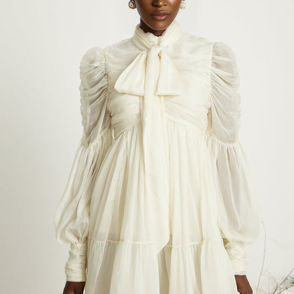 Paola Mini Dress in Neutrals sophisticated and stylish mock neck long puff sleeves buttoned cuffs tuck detailing gathered design pleated skirt rear zip fastening luxurious blend of Terylene fiber and Spandex timeless beauty