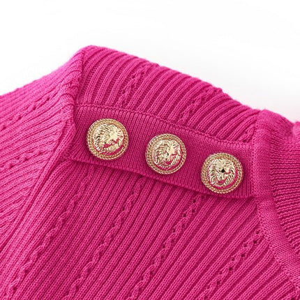 Pink fitted ribbed knit sweater with high neck design and decorative buttons on shoulders
