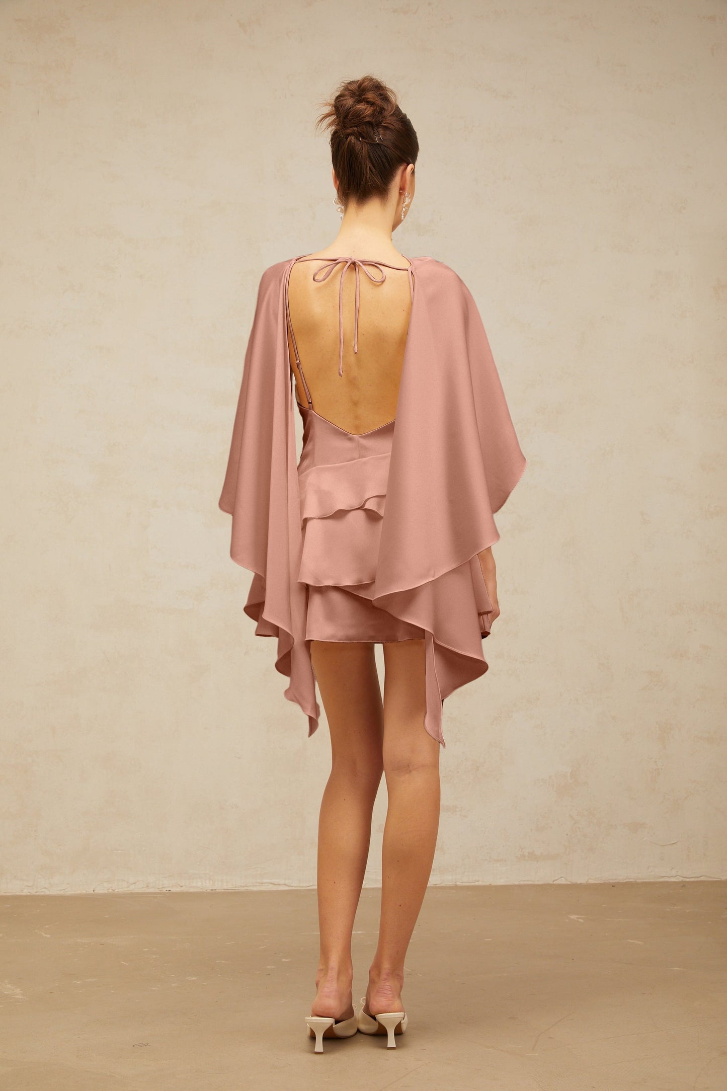 Pink satin mini dress with shawl panel and ruffled details called Lyna