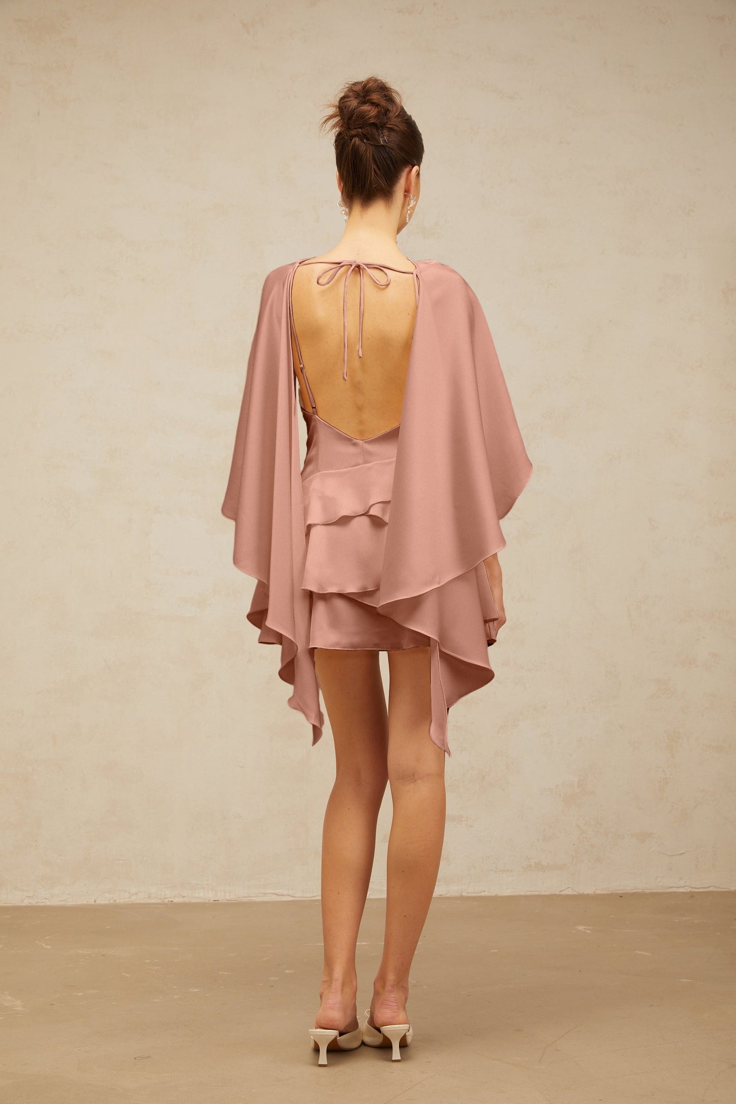 Pink satin mini dress with shawl panel and ruffled details called Lyna