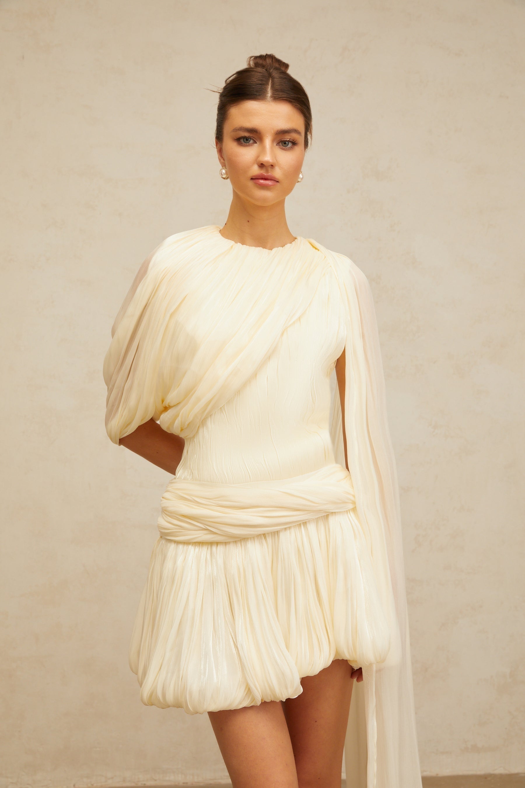 Pleated light colored mini dress with ribbon accent detail on waist and shoulders