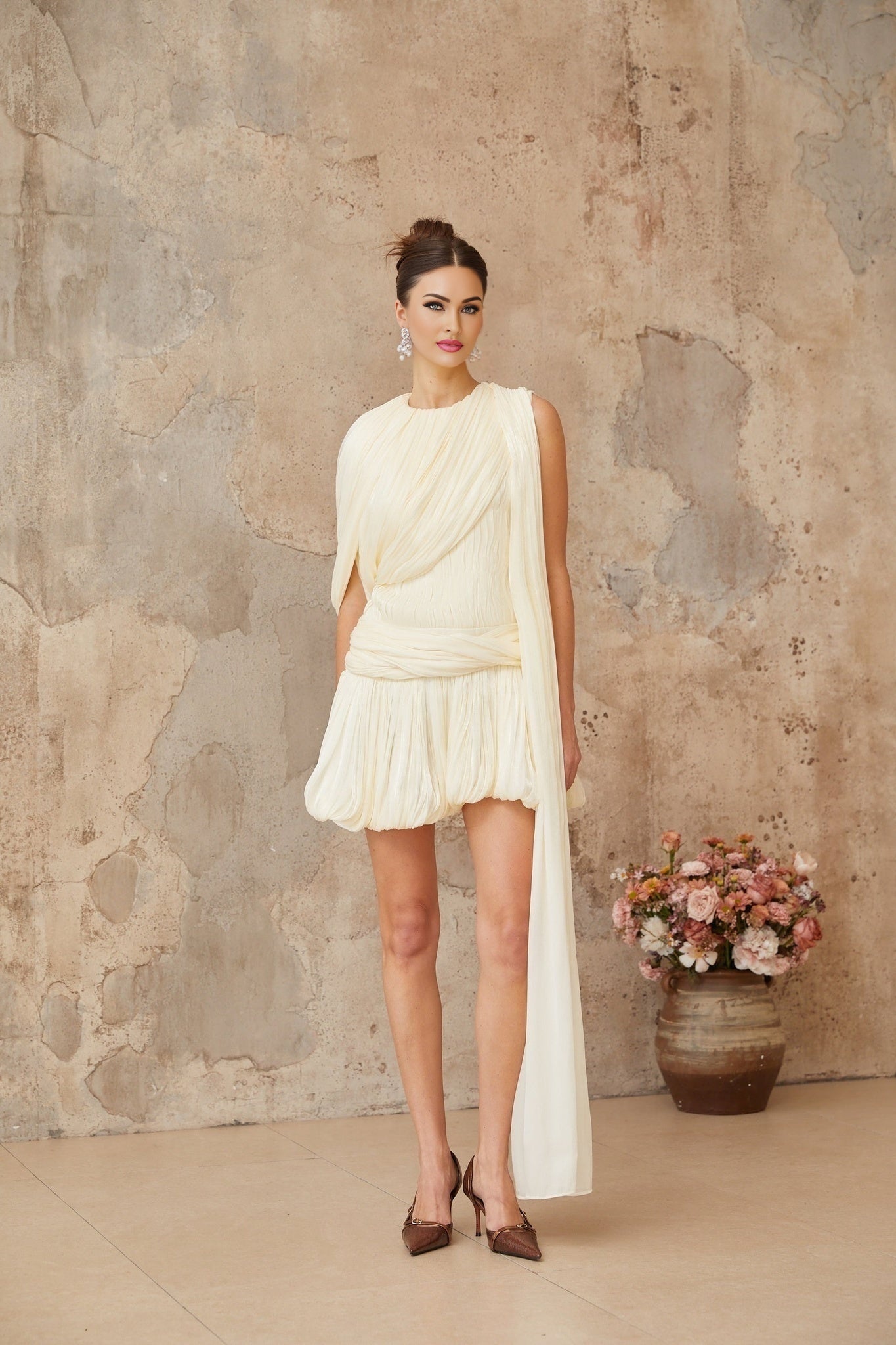 Pleated mini dress with ribbon accent in light color fabric featuring short sleeves and flowy design