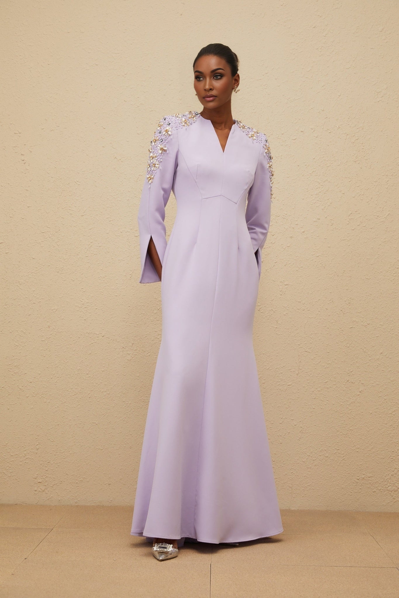 Purple long sleeve V-neck dress with faux pearl and crystal embellishments, fitted waistline, flared hem, rear zip fastening, floor length