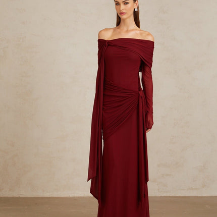 Woman wearing Red Juniper Twilight Sonata Gown with off-the-shoulder silhouette, long sleeves, and front tie detail