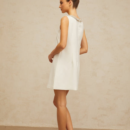 Serenity White Mini Dress with Faux-Pearl Crystal and Rhinestone Embellishments A-line Silhouette Bow Detailing Cut-Out Elements Rear Zip Fastening Thigh-Length Luxurious Blend of Terylene Fiber and Spandex Elegant Comfortable Statement Piece