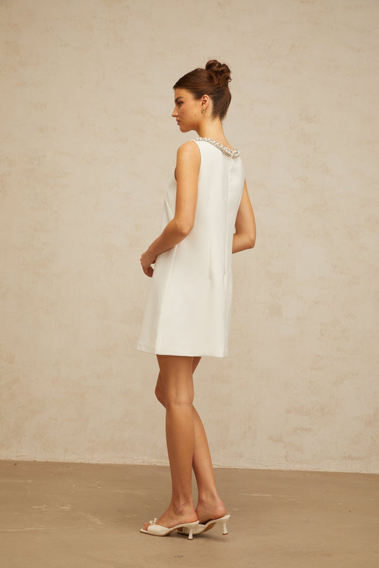 Serenity White Mini Dress with Faux-Pearl Crystal and Rhinestone Embellishments A-line Silhouette Bow Detailing Cut-Out Elements Rear Zip Fastening Thigh-Length Luxurious Blend of Terylene Fiber and Spandex Elegant Comfortable Statement Piece