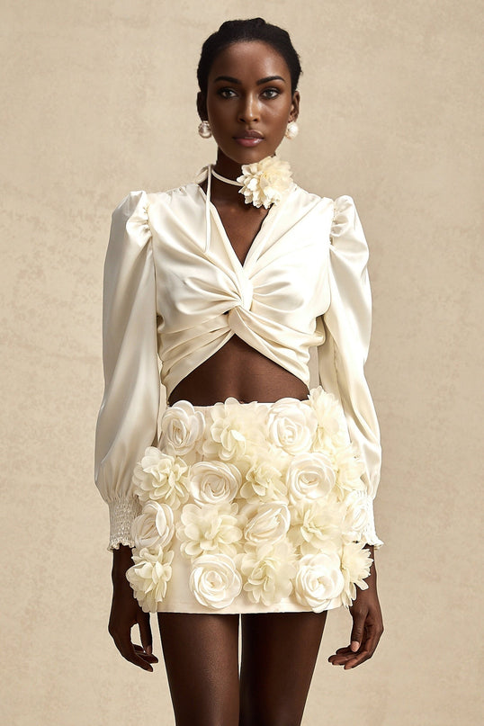 Short white top with twist pattern and artificial flowers called Nouria