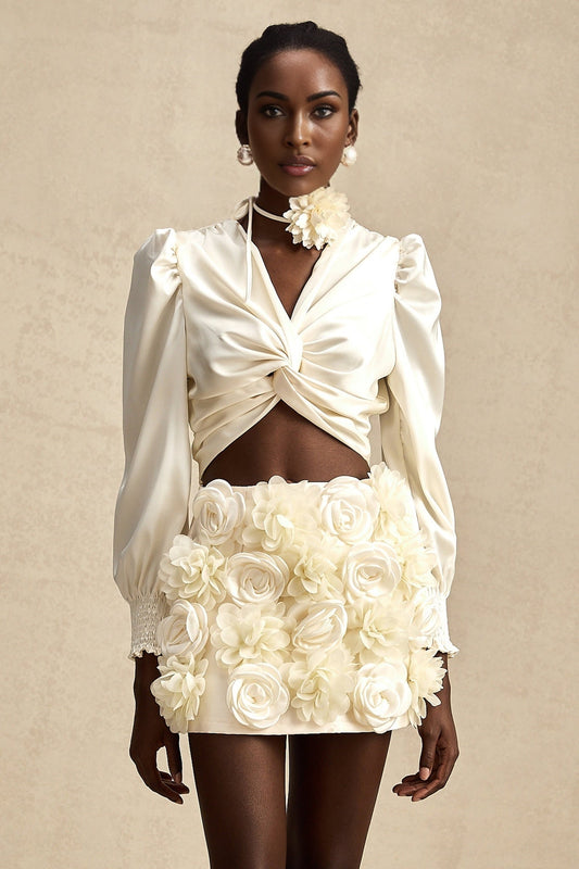 Short white top with twist pattern and artificial flowers called Nouria