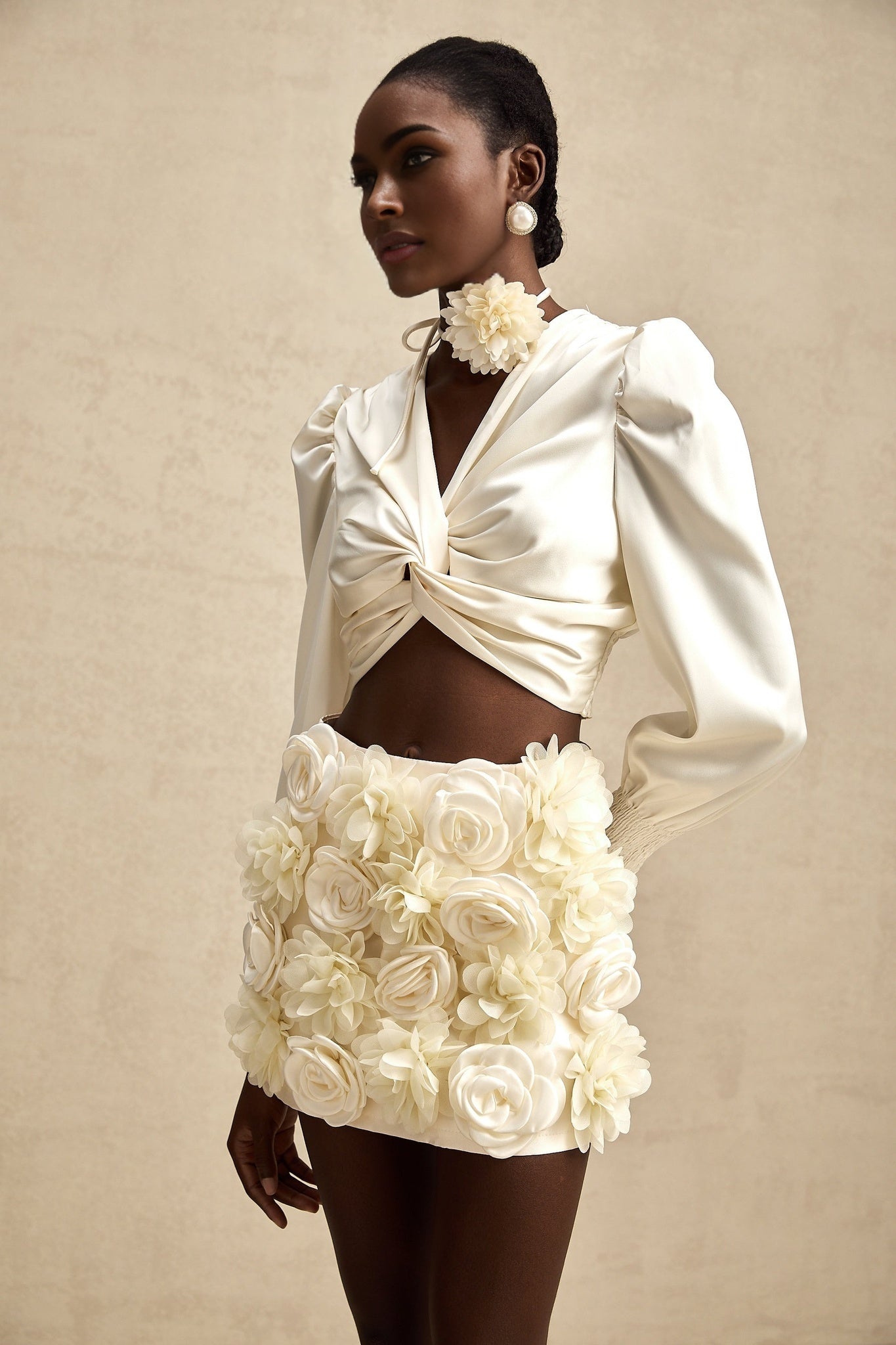 Short white top with twisted pattern and decorative artificial flowers