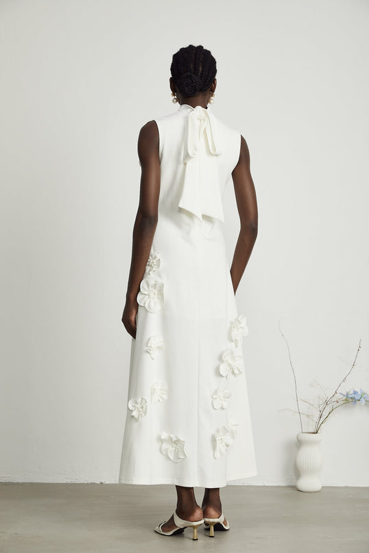 Sleeveless white maxi dress with bow and decorative artificial flowers named Magali