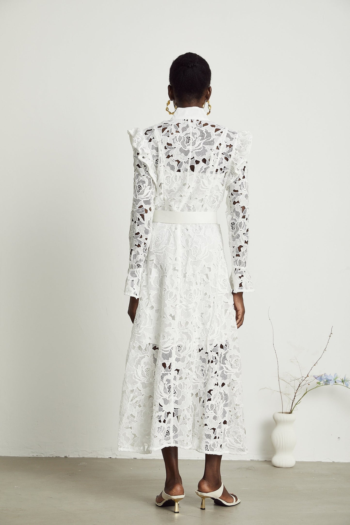 Sleeveless white midi dress with delicate floral embroidery details throughout the fabric