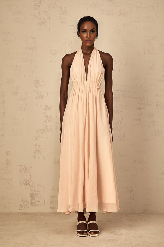 Teresa Maxi Dress in Peach Pink and Neutrals halter-neck silhouette shirred tulle open back design maxi length cinched waist 100% Terylene fiber intricate detailing rear tie zip fastening special occasions