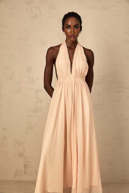 Teresa Maxi Dress in Peach Pink and Neutrals halter-neck silhouette shirred tulle fabric open back design maxi length cinched waist 100% Terylene fiber intricate detailing rear tie zip fastening special occasions